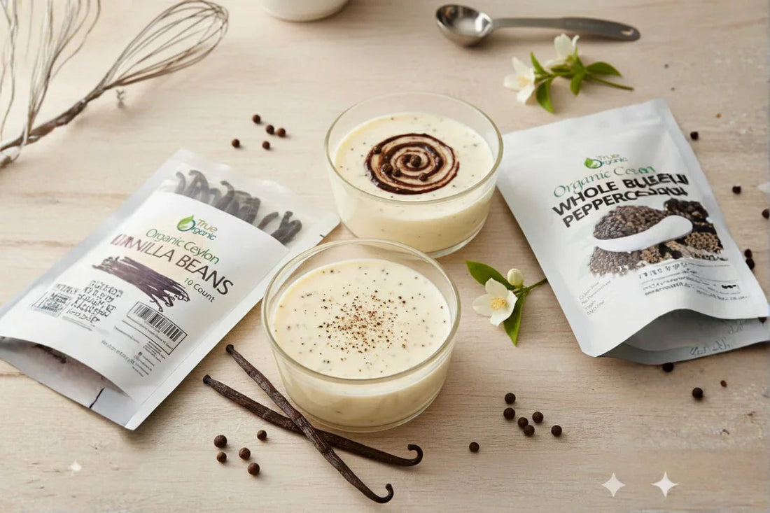 Two glasses of creamy vanilla dessert with vanilla beans, whole black peppercorns, and spice packaging