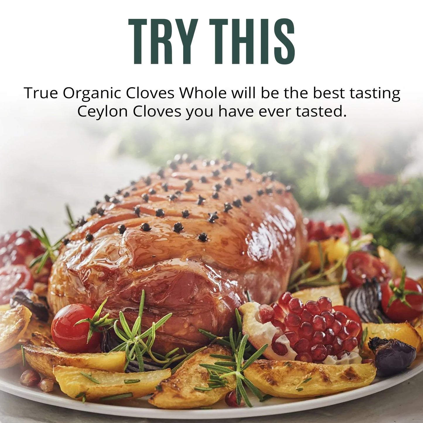 Glazed roasted ham studded with whole cloves on a plate with roasted vegetables and pomegranate seeds